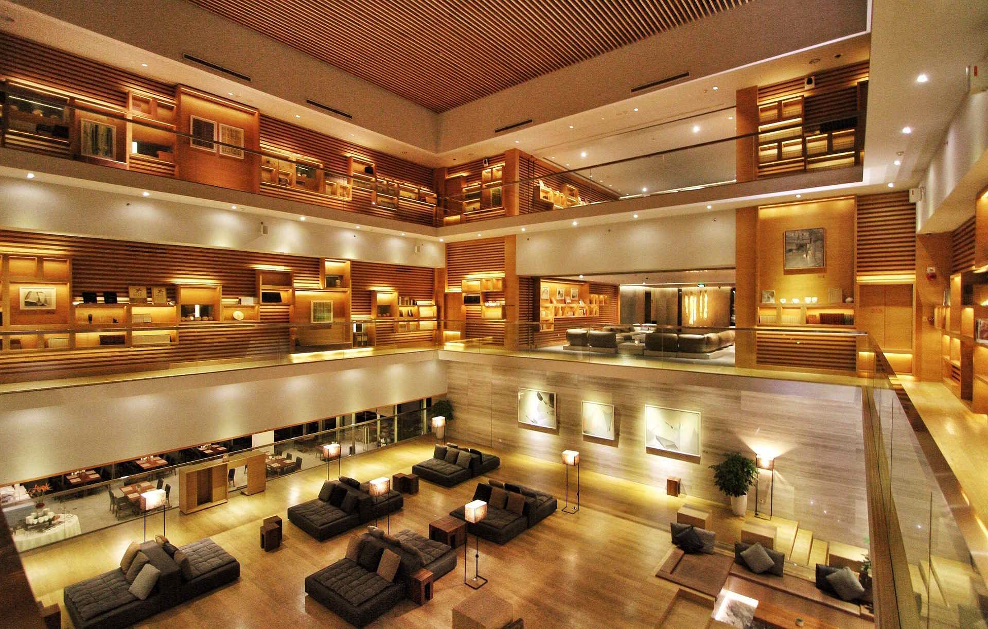 Multi-level hotel atrium lobby with warm lighting and lounge seating