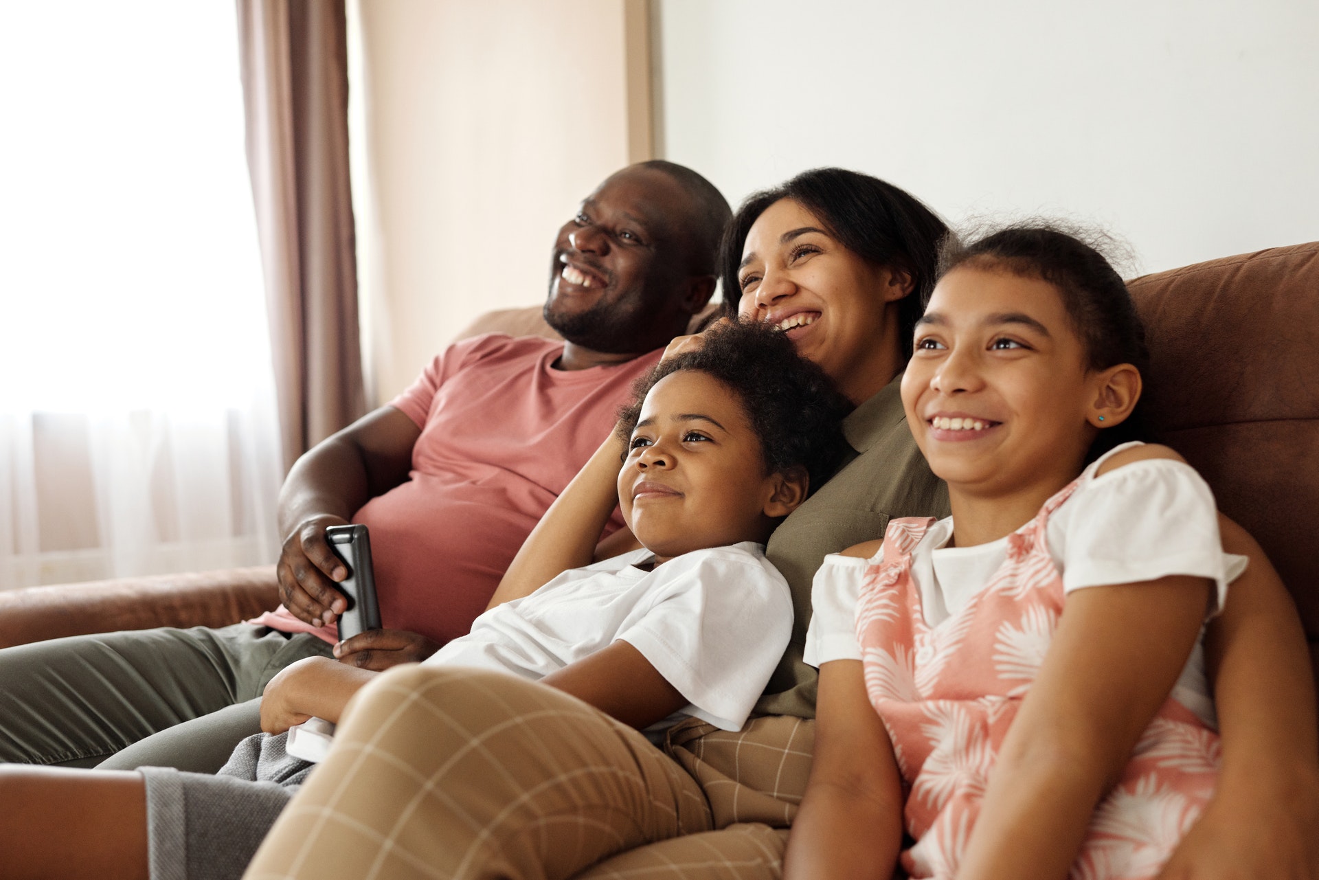 Family smiling together on the couch while watching the video wall