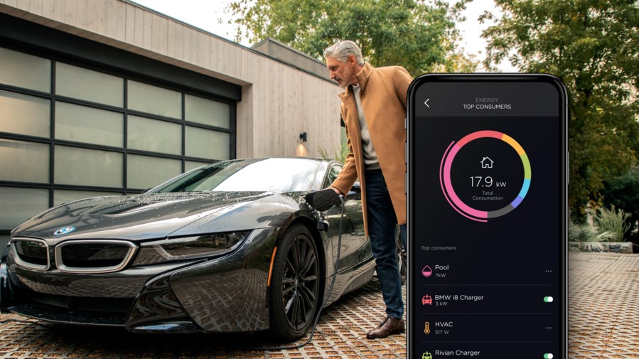 Savant energy management screen on an iPhone. A man charges an electric-powered vehicle in the background.