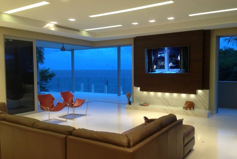 Oceanview room with a sectional, two chairs, and a large flat-screen TV.  