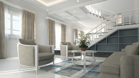 Ultra-modern and minimalist sunlit living room overlooked by open stairs with shades of white and gray throughout.