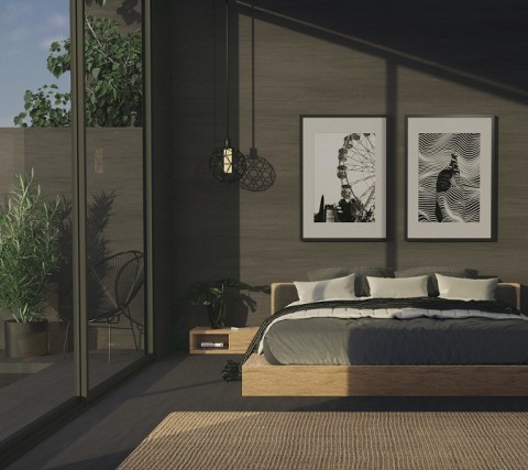 Natural sunlight washes through patio windows into a luxury bedroom with sophisticated prints hanging over a platform bed. 