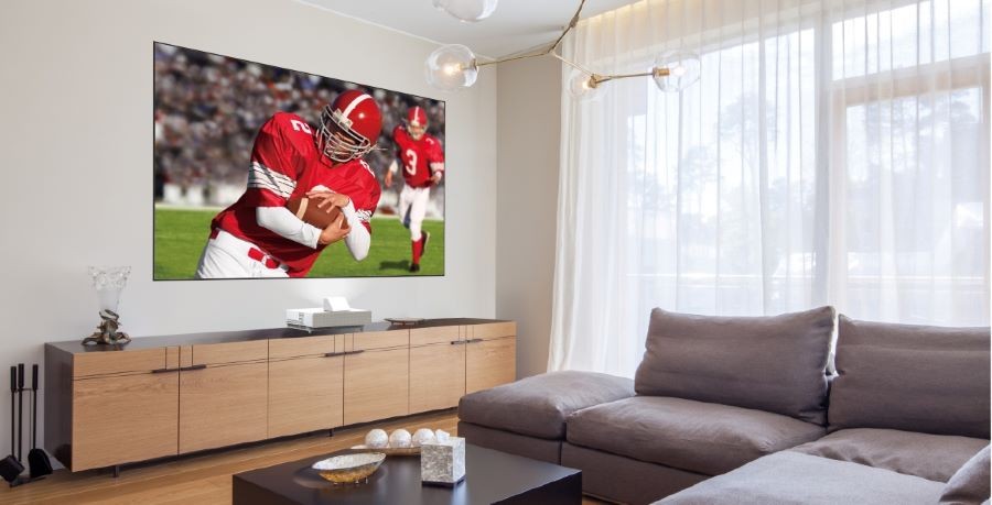A living room with an Epson LS500 short throw projector displaying a football game.
