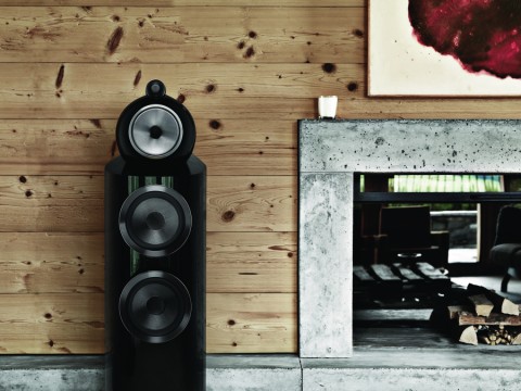 Close-up of a black Bowers & Wilkins 802D4 Speaker placed next to a fireplace. 