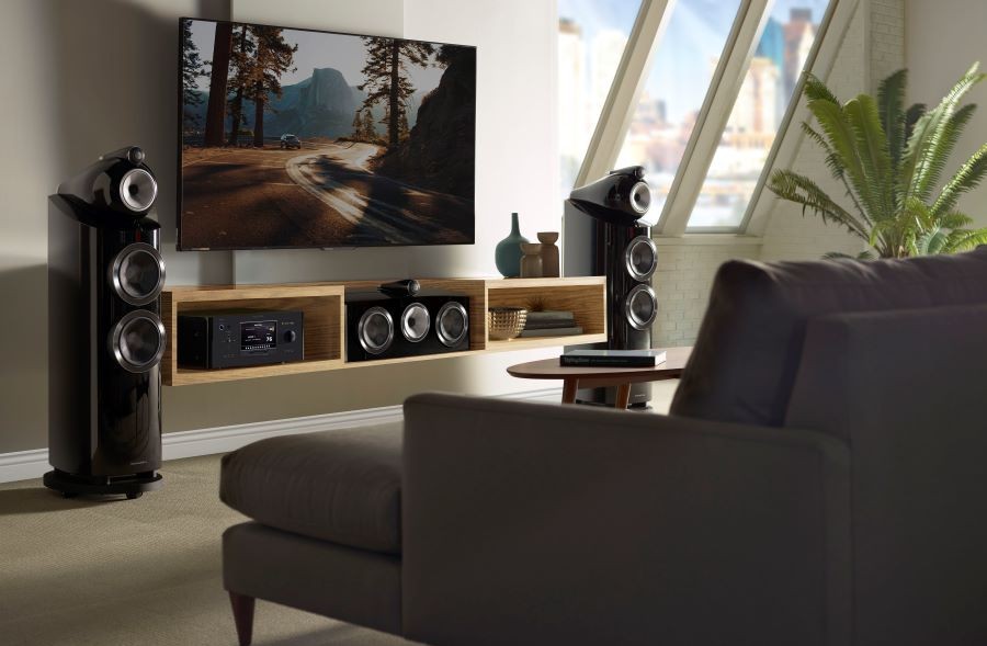 A room with B&W 802 D3 loudspeakers, a center channel speaker, and a flat panel TV.